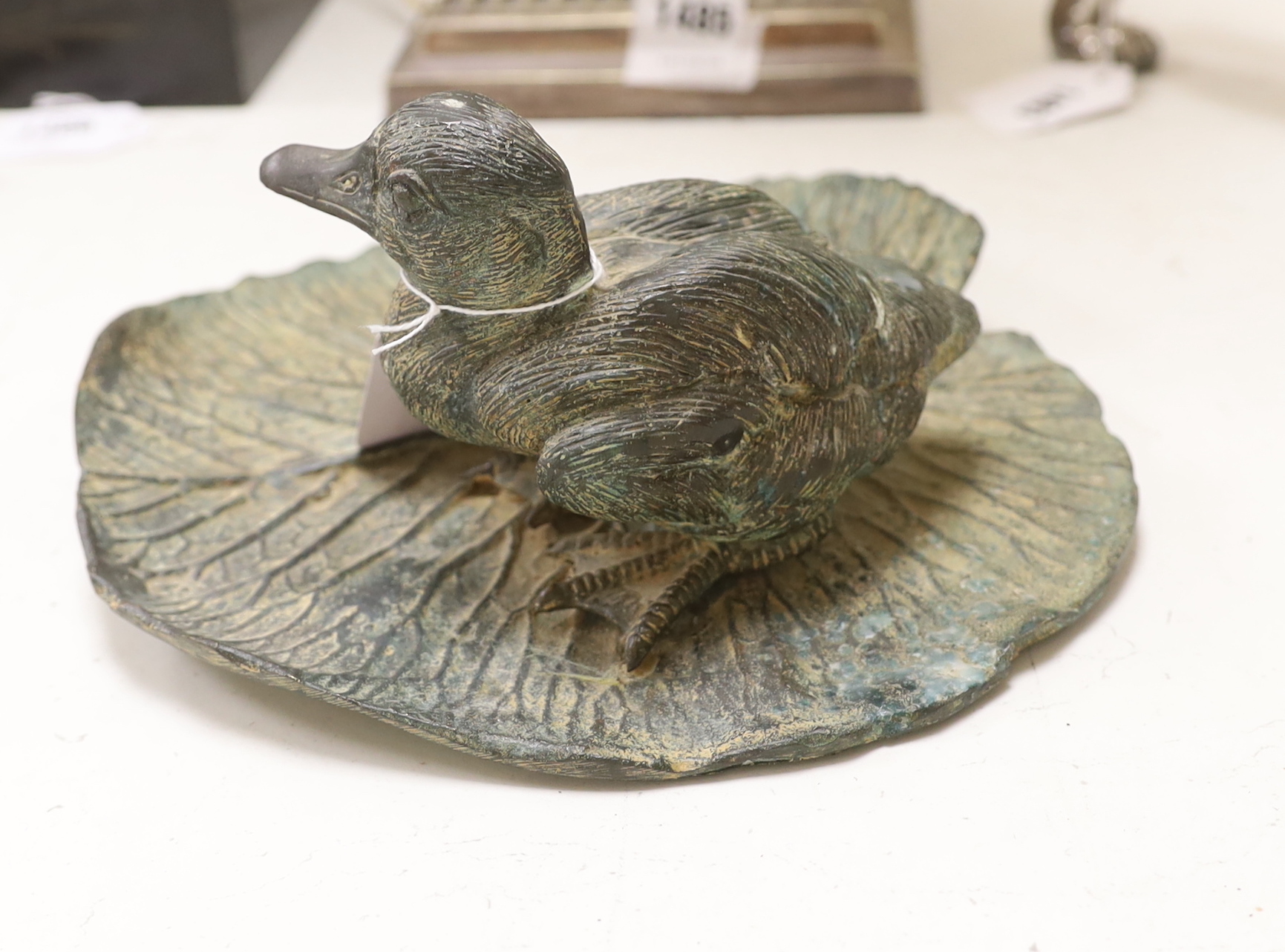 A bronze model of a duck on a lily pad, 23cm wide